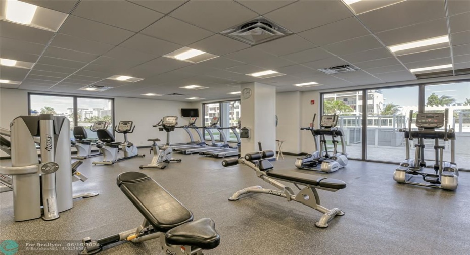 Updated Fitness Center with floor to ceiling windows overlooking pool deck