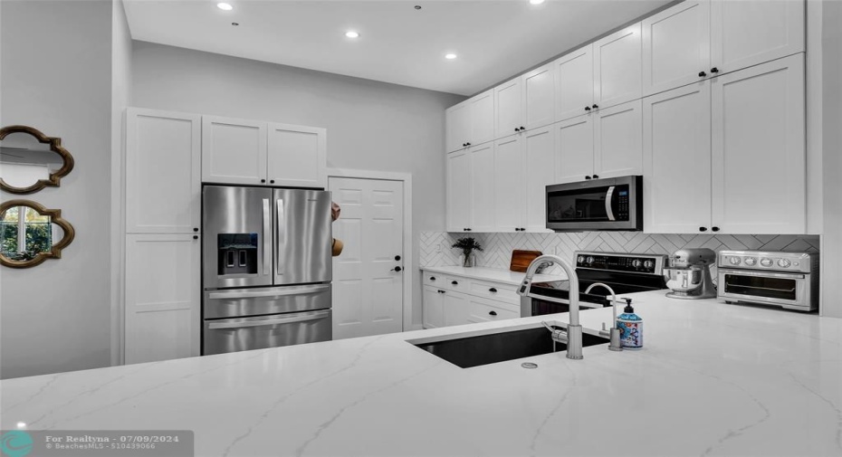 Kitchen  offers white shaker counters and stainless appliances