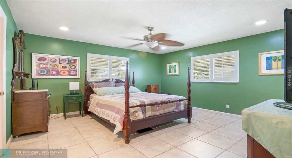 The master bedroom, with its spacious layout, walk-in closet, and elegant Plantation shutters on the windows, exudes both style and functionali