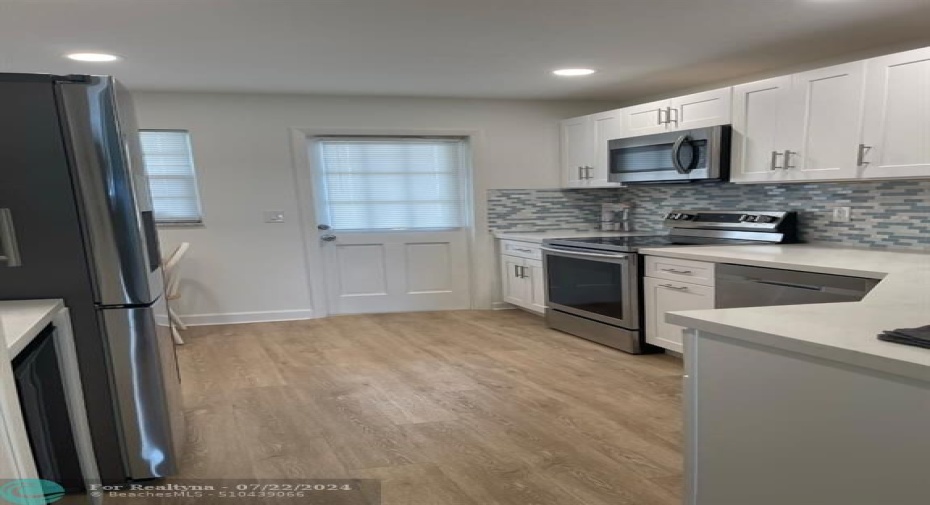 entry to gallery style  kitchen next to dining area