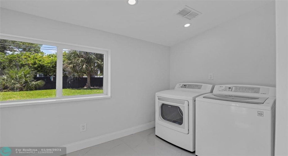 Large laundry room with door to backyard.
