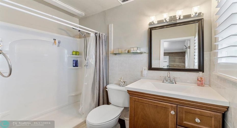 Primary bathroom features modern lighting and natural light!