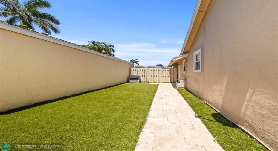 Private side yard with artificial turf with enough space for a boat trailer