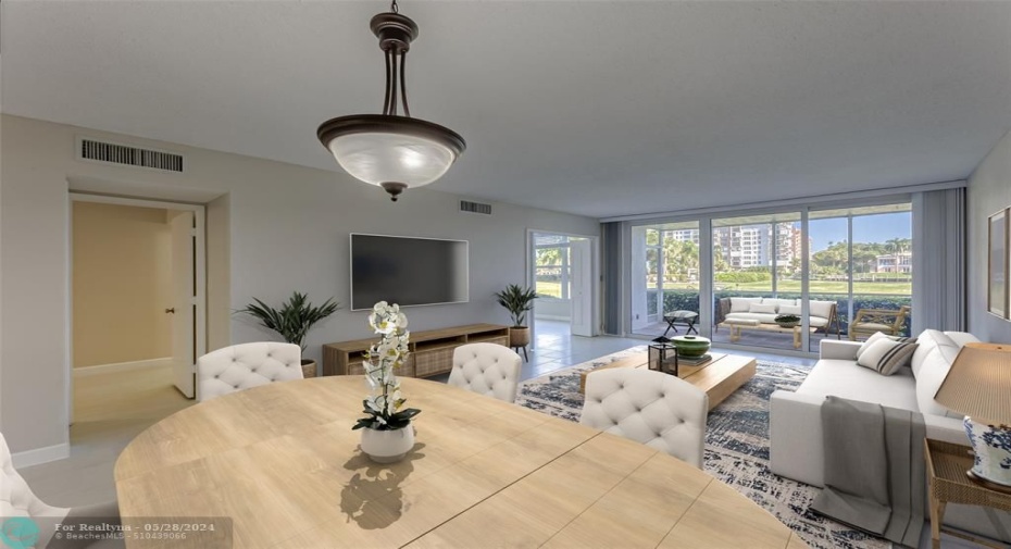 Large and spacious main living area offers great views of the water and offers tons of natural light from the impact sliders that take you out to your private screened patio - staged photo