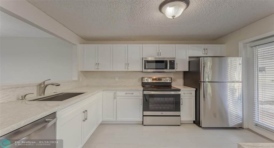 Kitchen has been renovated and is bright and cheerful featuring open breakfast bar into dining room and living room, quartz countertops and full backsplash, new white kitchen cabinets, brand new GE appliances, new kitchen sink & faucet and great natural light