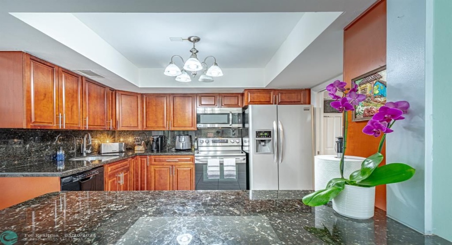 Open kitchen with granite counter tops and sitting area for 4 people