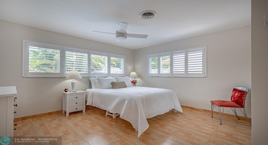 Spacious primary bed room, with closets, ceiling fan and plantation shutter on both windos.