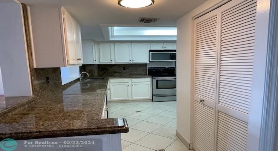The view into the kitchen, which is on your right as you enter the apartment. The washer and the dryer are behind the louvered doors.