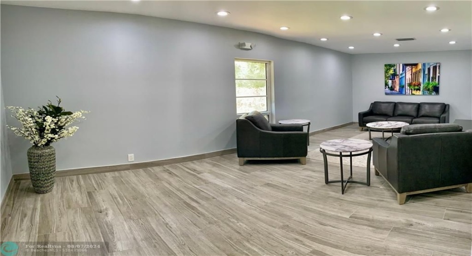 Air conditioned rec area with seating on one side and card tables on the other.