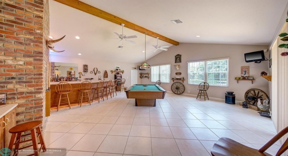 Game room, wet bar, vaulted ceilings with lots of windows and access to screened in patio