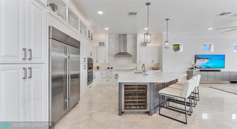 White cabinets from floor to ceiling with beautiful under & over lighting for displays, Stainless appliances 