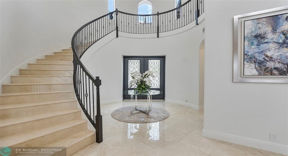 Solid wood doors seal the entryway of this magnificent Foyer as you enter into this spectacular home, Circular banister adorns the stairway to the 2nd floor, This stairway is the main tower to the home and has tower arched windows above to view outsid, The staircase is marble perfection like brand new,