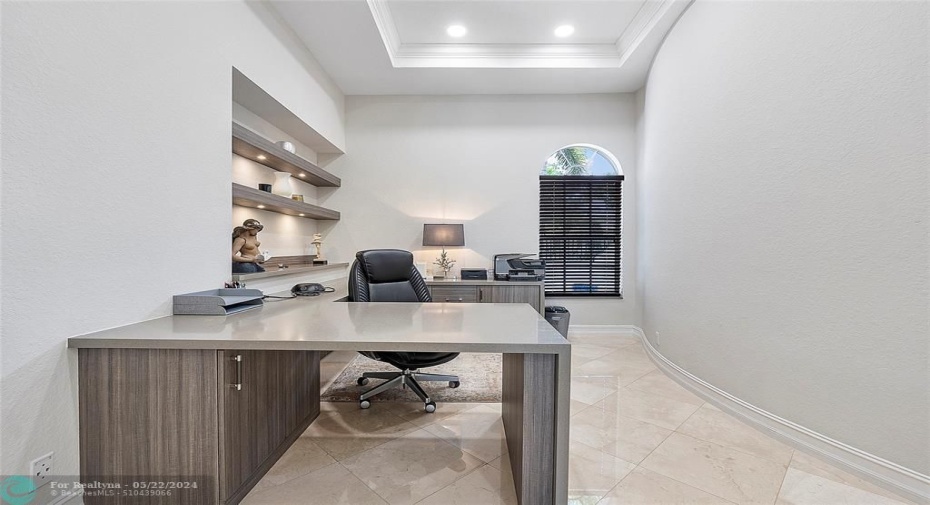 Built in office with underlighting shelving & waterfall quartz countertop, tray ceiling and LED lighting