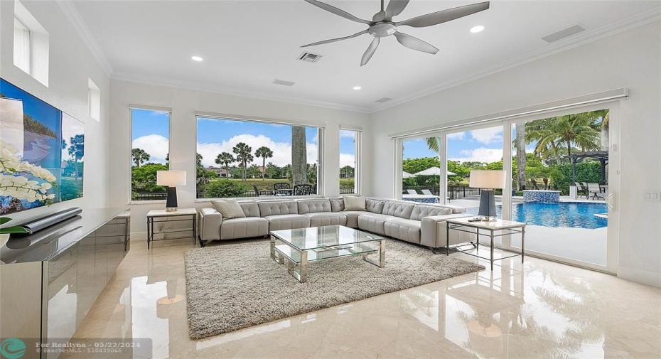 View of family room from the kitchen looking out onto the pretty private landscape of pool, patio and Palm trees!