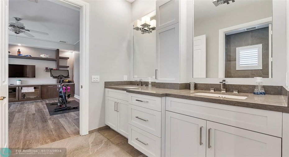 Modern full bathroom with plenty of cabinet space and mirror chandeliers