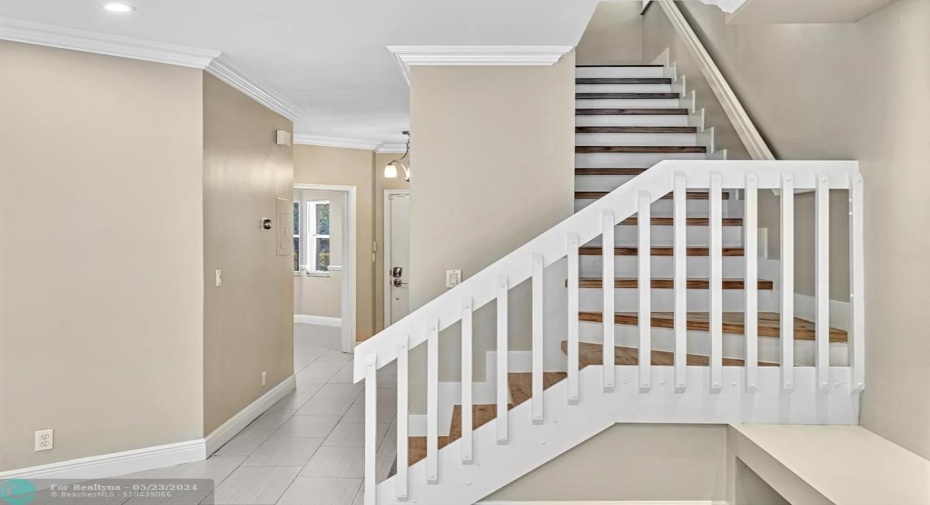 Foyer entrance with, from left to right: Formal Dining Room entrance, Front Door and Stairs to Bedrooms