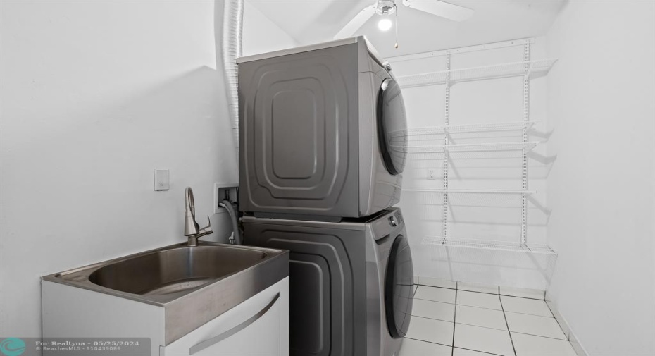 Separate laundry room with storage space.
