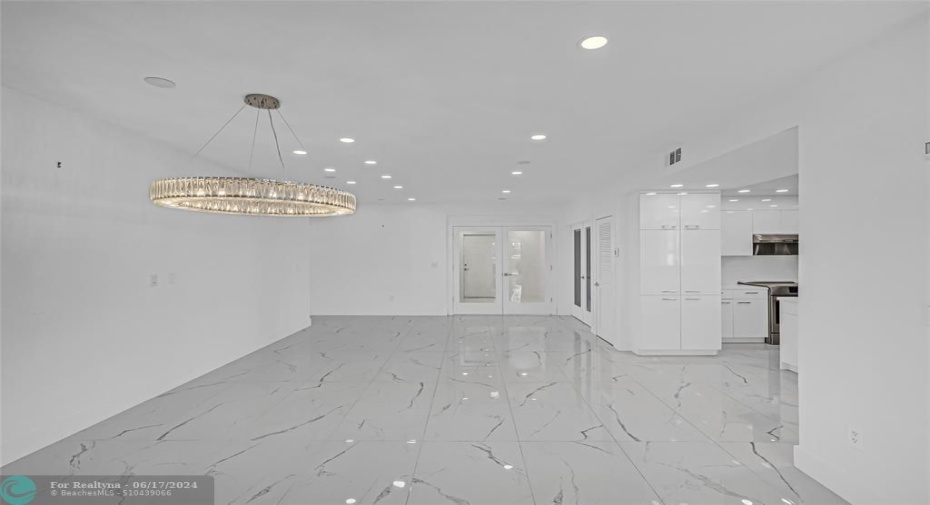 Dining room with custom lighting and additional recessed lighting with marble flooring
