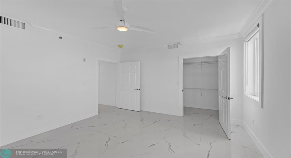 third bedroom with walk in closet and marble flooring
