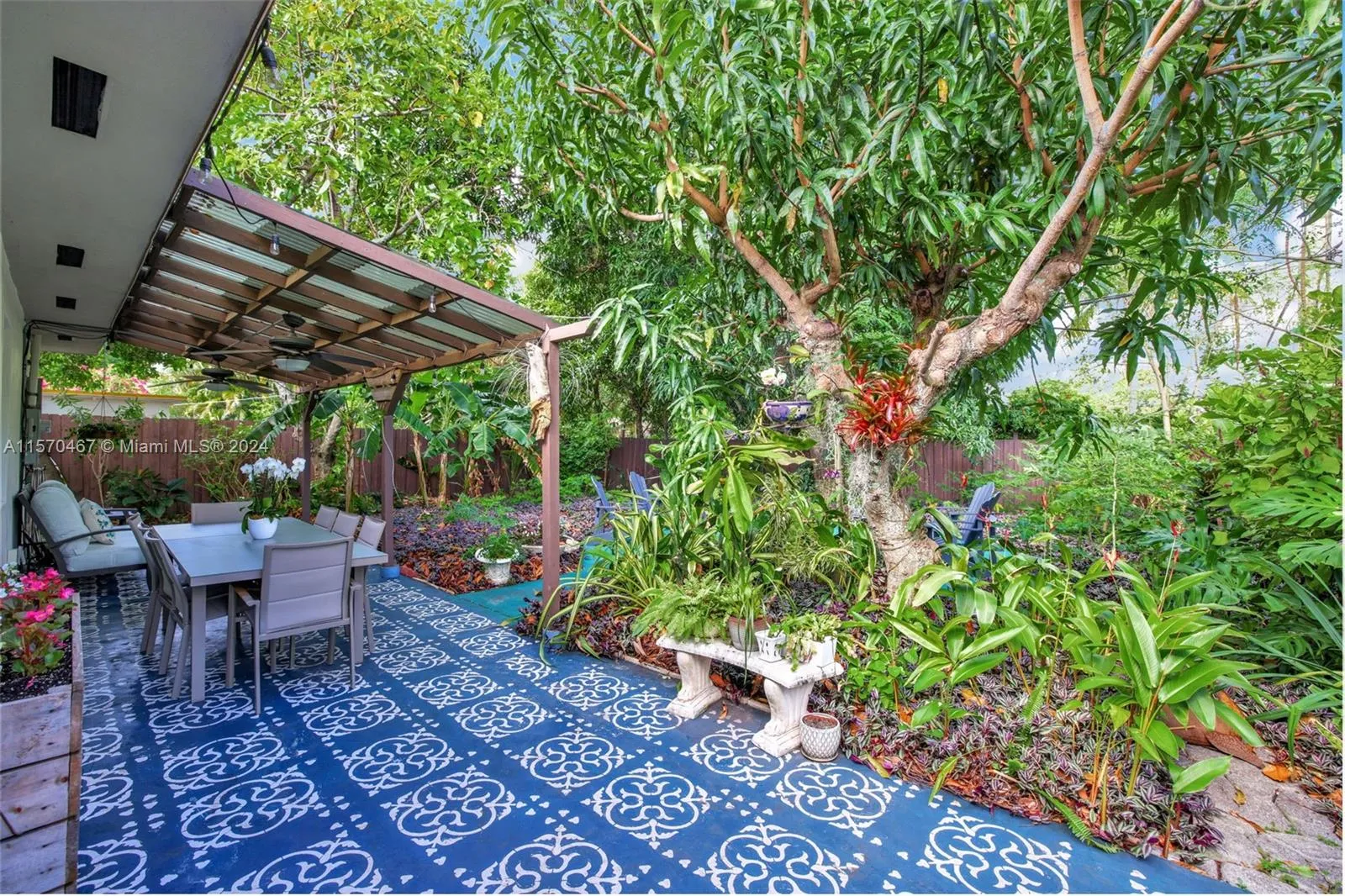 Beautiful covered patio overlooking lush garden with mango, avocado, papaya, banana, nase berry / sapodilla and other decorative plants, including orchids and jasmine