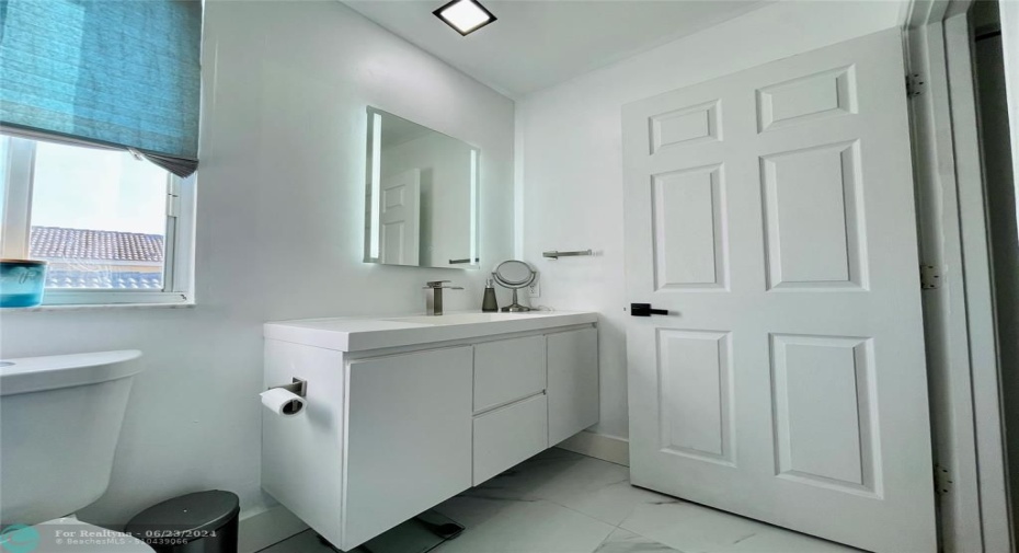 this bathroom exudes a modern and elegant ambiance, with high-quality finishes and a thoughtful design that emphasizes both aesthetics and functionality. Additionally, recessed ceiling lights provide ample illumination, ensuring the bathroom is well-lit both day and night.