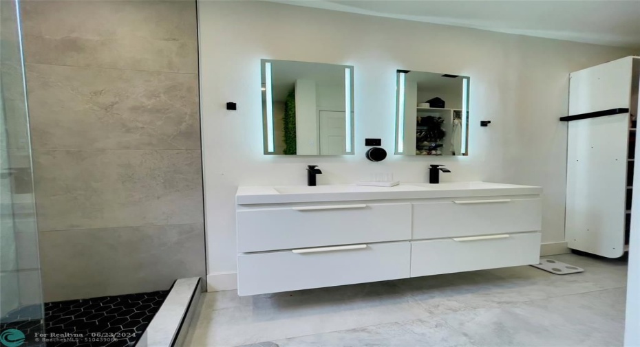 This bathroom exudes a modern and elegant ambiance, with high-quality finishes and a thoughtful design that emphasizes both aesthetics and functionality. Additionally, recessed ceiling lights provide ample illumination, ensuring the bathroom is well-lit both day and night.