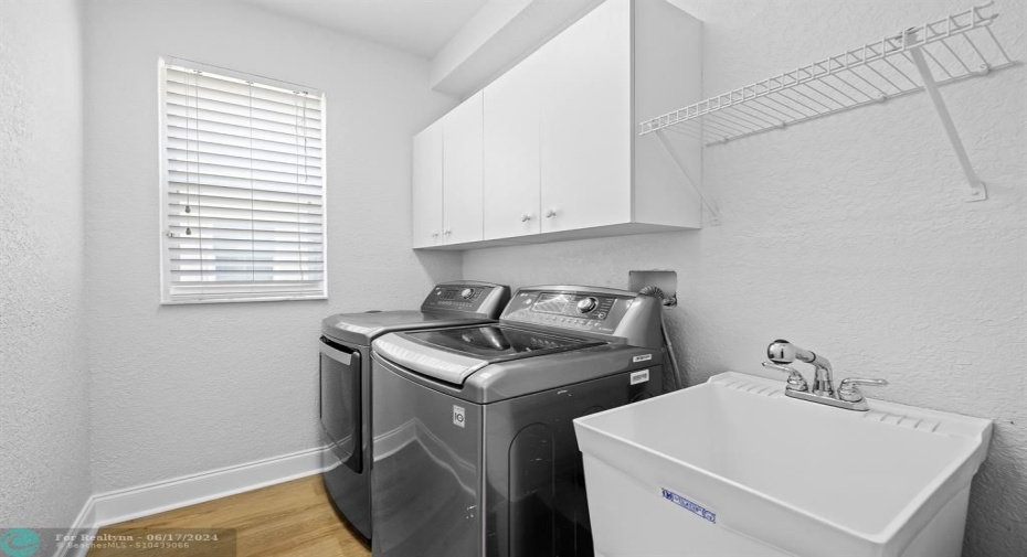Full size utility room located on first floor featuring mud sink and extra storage