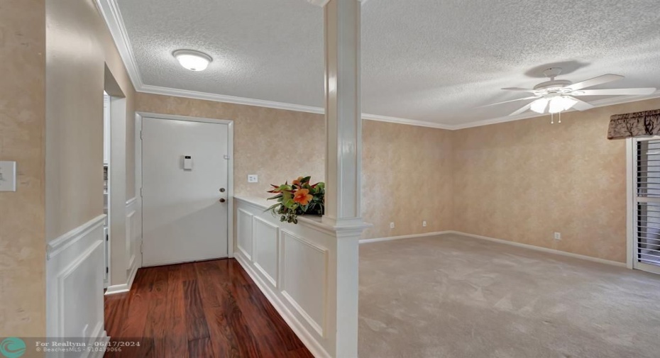 Foyer entry boasts wainscoting and rich.engineered hardwood floors.