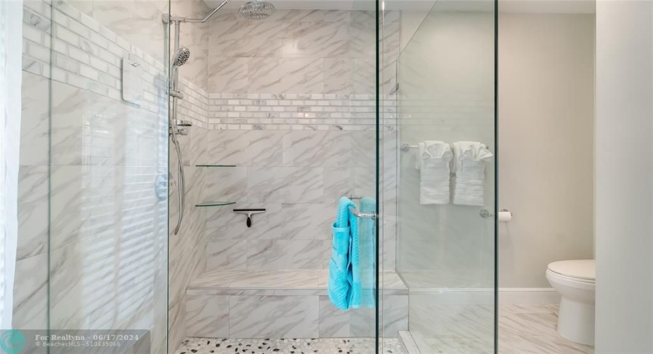 The oversized frameless glass shower boasts massaging body jets and a oversized rainfall showerhead.