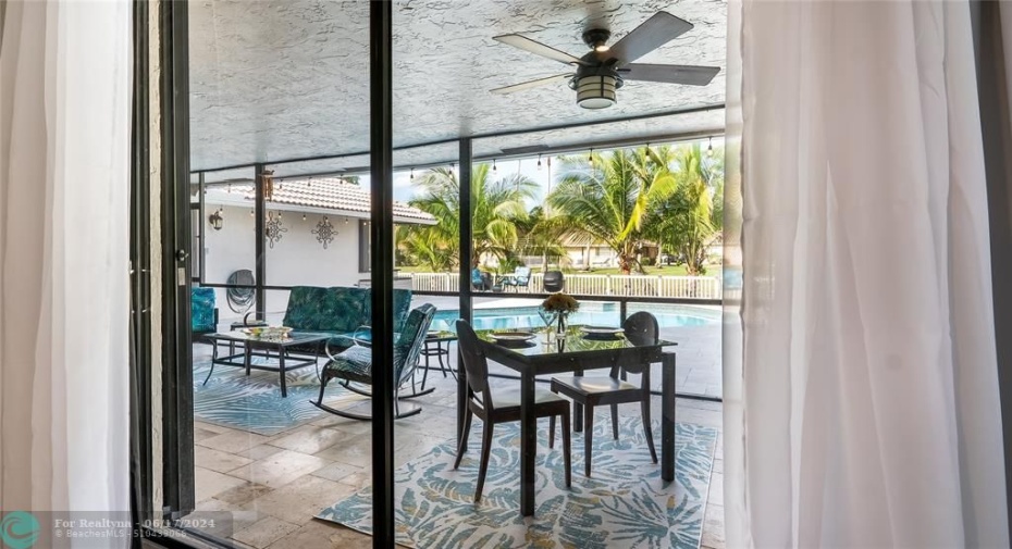Just beyond the sleek glass doors lies a true outdoor living oasis - the spectacular covered patio space. This exceptional extension of the home seamlessly blends interior comfort with the beauty of Florida's lush natural surroundings.