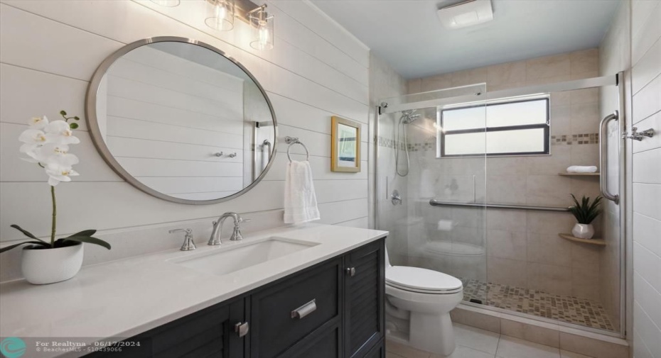 Bathroom 2. Completely remodeled with new glass shower doors and vanity, humidity sensor vents, shiplap walls.