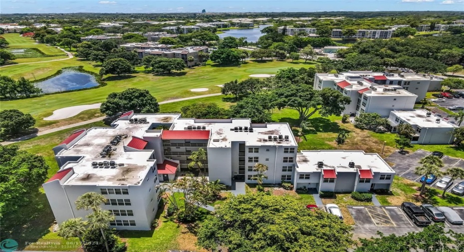 Aerial of the well maintained building surrounded by beautiful landscaping, and lots of guest parking