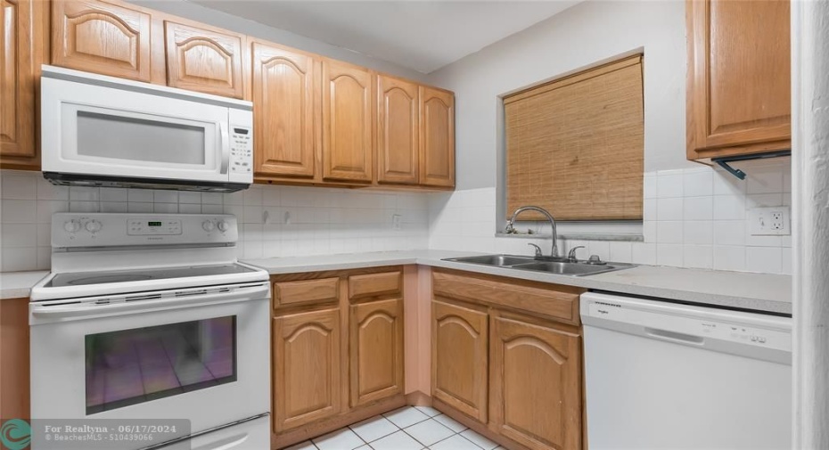 Bright kitchen with wood cabinets ample counter space.