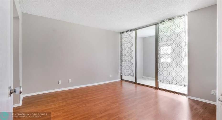 Spacious master bedroom with laminate flooring, impact windows and door to your converted patio.