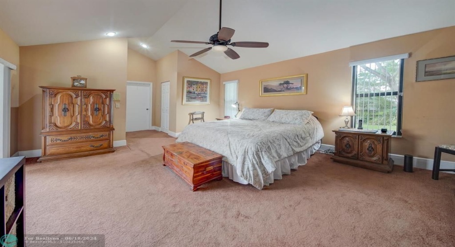 huge master bedroom suite with vaulted ceilings and sliding glass doors to pool and patio.