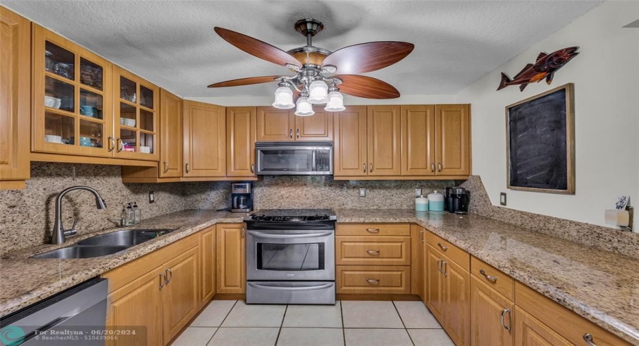 Kitchen offers granite counters, wood oak cabinets, Stainless appliances and overhead fan with lighting
