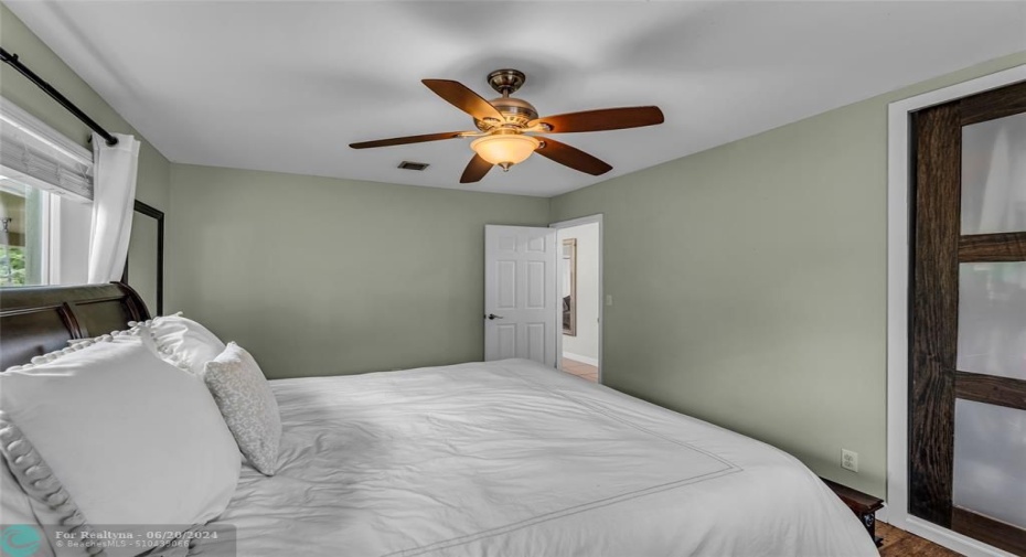 Spacious master bedroom with overhead ceiling fan with lighting