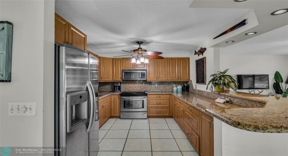 Kitchen is open with stainless steel appliances and oak wood cabinets