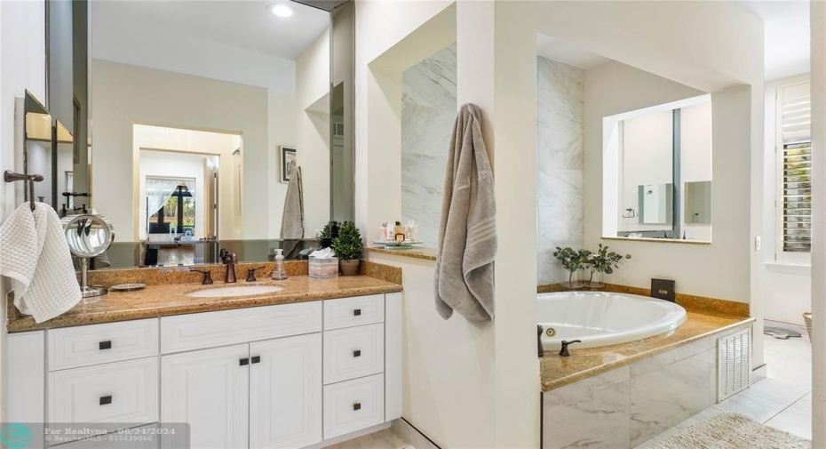 Master bathroom features separate vanities jetted tub, a separate updated shower