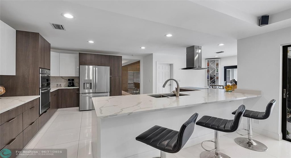 Entertainer's dream kitchen with large peninsula/bar with double waterfall effect quartz countertops