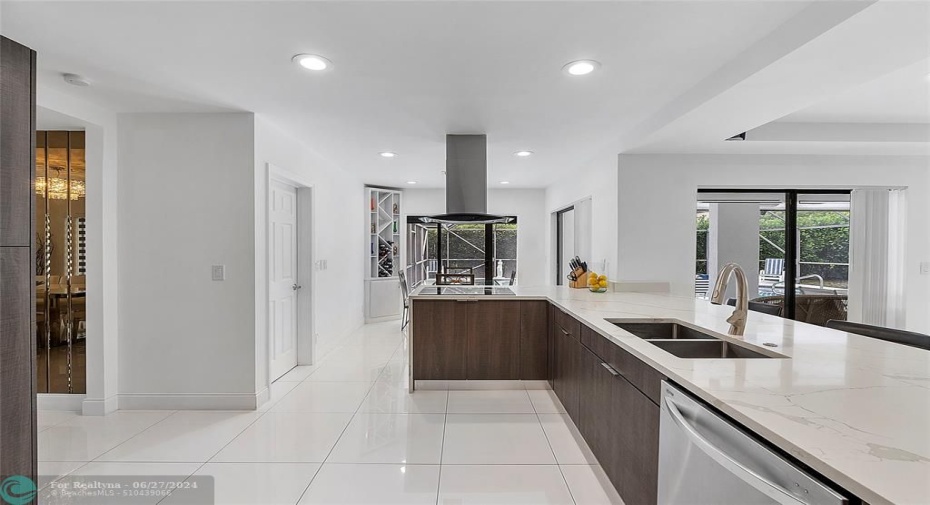 Light and bright chef's kitchen with stainless steel appliances, ceramic cook top and vent hood