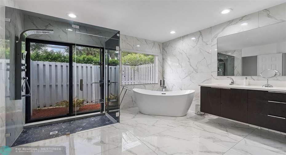 Gorgeous primary bathroom with floor to ceiling marble look tiles