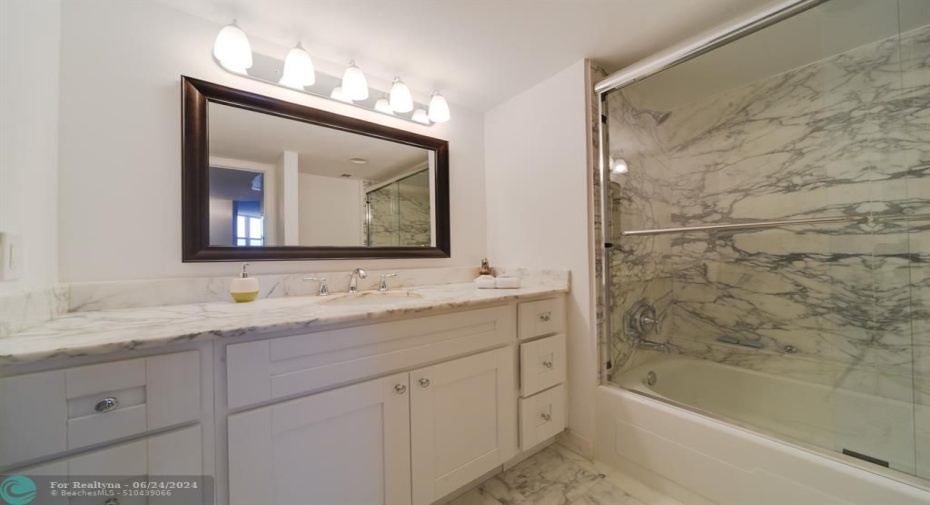 Second bathroom offers a tub / shower combo with light and bright counters and cabinets