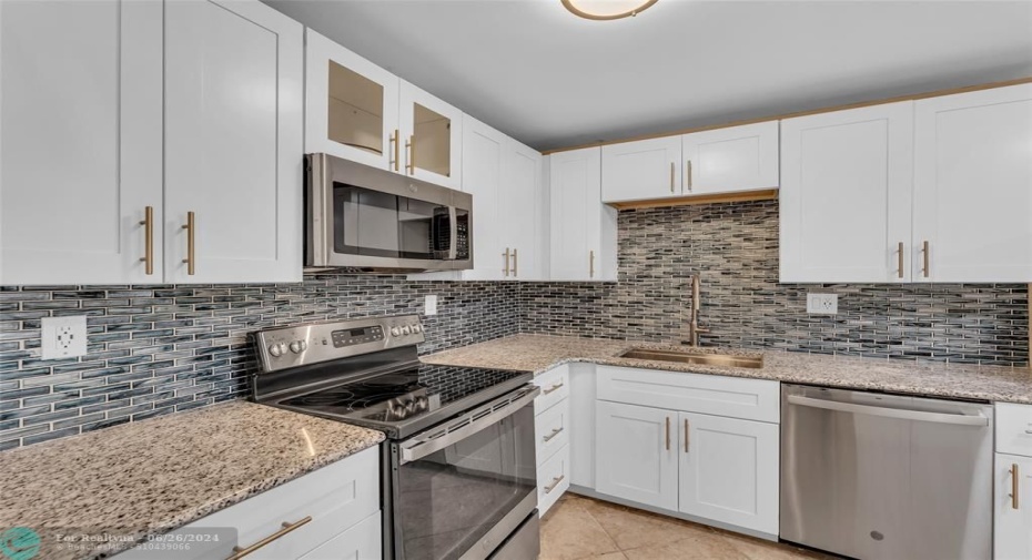 Updated kitchen with white cabinets and stainless steel appliances
