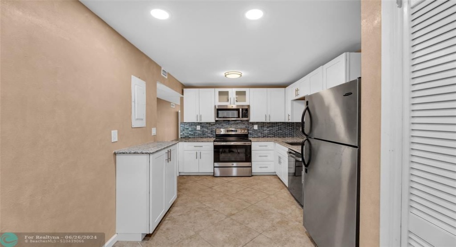 White cabinets and stainless steel appliances and recessed lighting