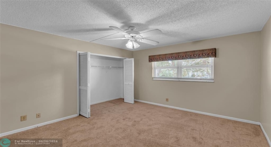 Master bedroom with carpet flooring and oversized wall closet
