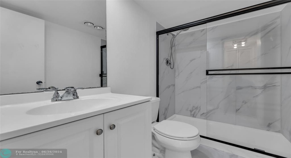 Second bathroom has been remodeled and offers a walk in shower with white counters and cabinets