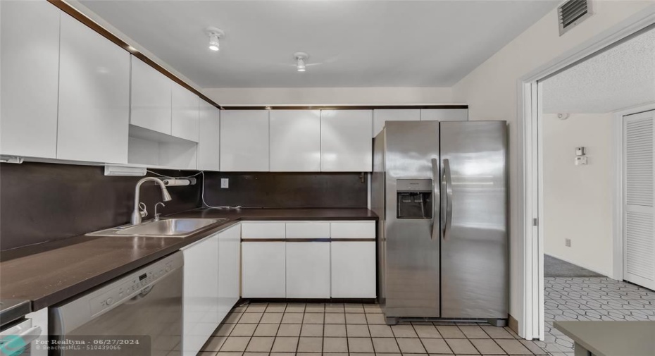 Kitchen offers white cabinets and stainless steel appliances