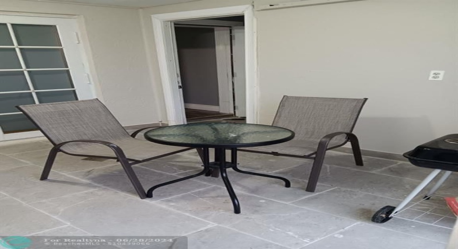 ENCLOSED PATIO FURNISHED WITH TABLE AND TWO CHAIRS