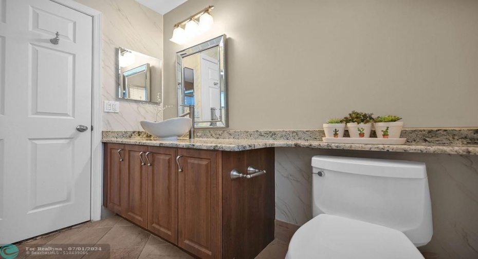 Lovely, windowed, upgraded guess bathroom has large sink, granite counters, walk-in shower with upgraded tile, & a linen closet.